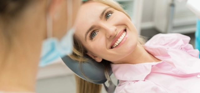 uśmiechnięta pacjentka patrząca na dentystkę